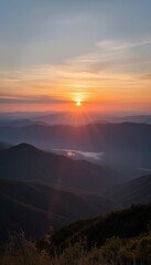 Sunrise over mountains with valley and misty landscape  