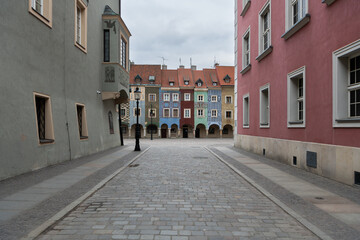 Obraz premium Colorful medieval merchant houses with arches on the old market square, Stare Rynek in the city centre of Poznan, Poland. Wonderful must-see touristic spot. Old houses with different colors, architect
