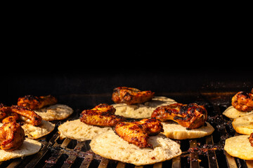 Grilled Chicken Wings on Flatbread Cooking Over Open Charcoal Grill