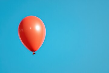 Obraz premium minimalistic stock photo of single red balloon floating against bright blue sky symbolizing joy and celebration
