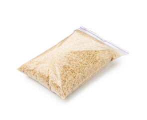 Raw brown rice in plastic bag isolated on white