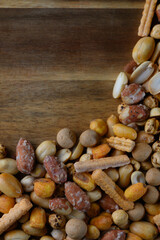 Colorful assortment of mixed nuts and snacks displayed on a wooden platter for an inviting party atmosphere