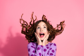 Charming cute Brown-Haired Girl Expressing Excitement in a Purple Polka Dot Outfit Against a Pink Background