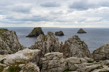 Vue depuis les hauteurs de la presqu'île, embrassant l'immensité de l'océan sous un ciel  bleu légèrement voilé.