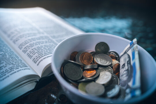 Coins with Holy Bible, a closeup, Christian biblical concept of tithing, Biblical concept of Christian offering