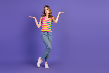 Young smiling woman in casual clothing showing a cheerful gesture against a vibrant purple background