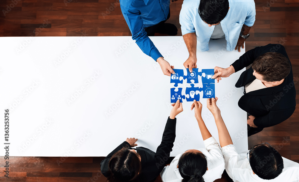 Aufkleber This image captures a diverse group of professionals collaborating over a puzzle on a table, symbolizing teamwork and strategic problem-solving in a modern office environment. Amity