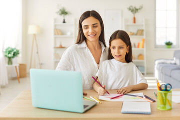Kind mother and daughter family at laptop online, distance learning, helping young teacher, babysitter girl, small pupil doing class, learning, home work lesson, writing, studying together, developing