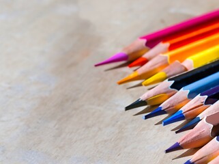 Obraz premium Colored crayons on gray background. Color pencils on a light gray background. Top view with space for text. Back to school concept. Spectrum of different colors.