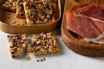 Cereal cracker and prosciutto on the table