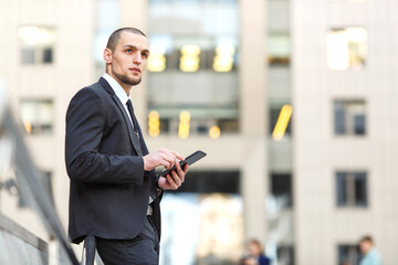 Businessman using digital tablet against blurred office building background. Business man working on tablet pc.