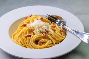 close up of spaghetti carbonara in white bowl