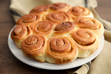 Freshly baked cinnamon rolls on wooden table, closeup