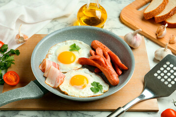 Tasty brunch. Fried eggs, sausages, bacon and spatula on white marble table, closeup