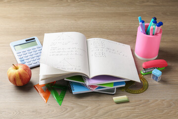 Doing homework. Notebook with math assignment and stationery on wooden desk