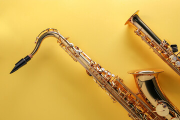 Jazz. Shiny saxophones on yellow background, top view