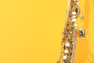Golden soprano saxophone on yellow background, closeup. Space for text