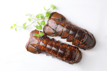Raw lobster tails and microgreens on white marble table, flat lay