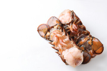 Raw lobster tails on white table, closeup. Space for text