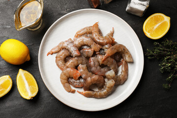 Fresh raw shrimps, spices and lemons on grey table, flat lay