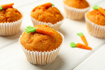 Tasty carrot muffins on white wooden table, closeup