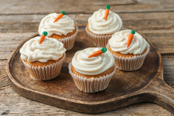 Delicious carrot cupcakes on wooden table, closeup