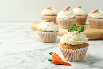 Delicious carrot cupcake with mint on white marble table, closeup. Space for text