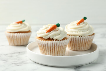 Delicious carrot cupcakes on white marble table, closeup
