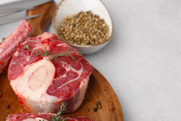 Pieces of raw beef and spices on light grey table, closeup. Space for text