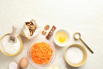 Different ingredients for making carrot cake on beige textured table, flat lay. Space for text