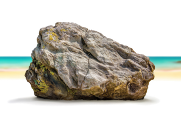 a rock on a beach with a blue sky in the background cutout and isolated on transparent background 