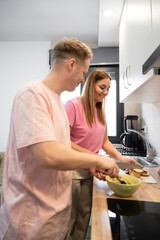  vertical photo of a couple cooking together
