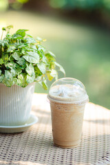 Glass of iced coffee with coconut on wooden table in coffee shop, copy space and isolate concept.