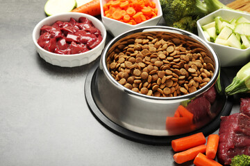 Dry pet food and natural products on grey table, closeup