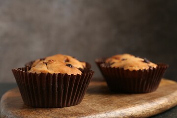 Delicious muffin with chocolate chips on table, closeup