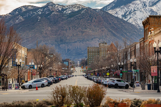 Ogden, UT, US-March 23, 2025: Historic downtown of this Utah city with quaint brick buildings and scenic snow-capped mountains in background.
