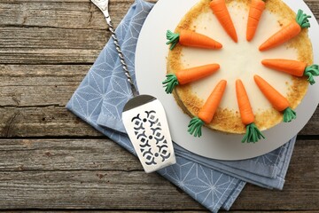 Delicious homemade carrot cake and server on wooden table, top view. Space for text