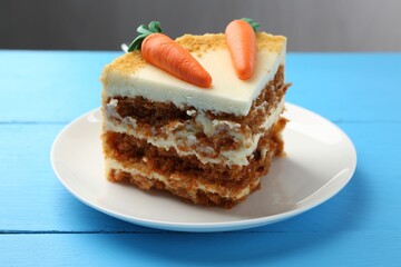 Piece of delicious homemade carrot cake on light blue wooden table, closeup