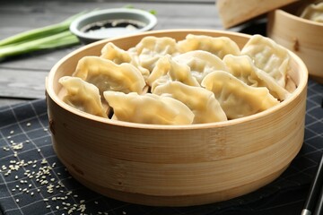 Tasty boiled gyoza (dumplings) served on black table, closeup
