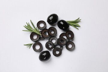 Marinated black olive rings, whole fruits and rosemary on white background, flat lay