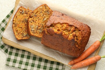 Homemade carrot cake with nuts and vegetables on table, top view