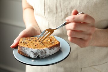 Woman with piece of homemade carrot cake and fork indoors, closeup