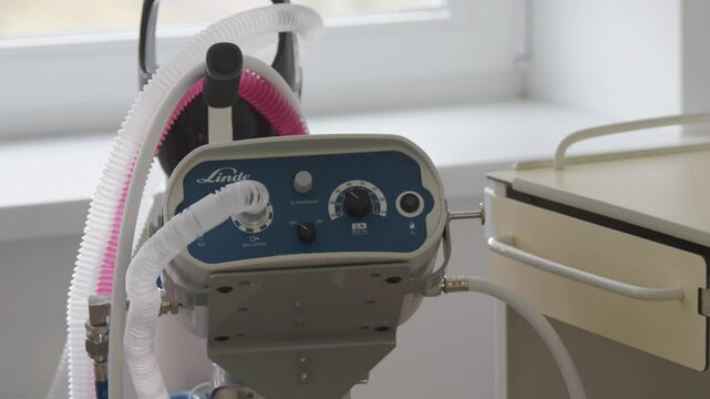 Close-up of a Linde medical gas delivery system with oxygen and nitrous oxide controls in a hospital setting, placed near a window and cabinet.