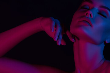Female portrait in neon lighting with futuristic pink and blue tones