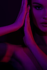 Moody portrait of young female with purple and red lighting