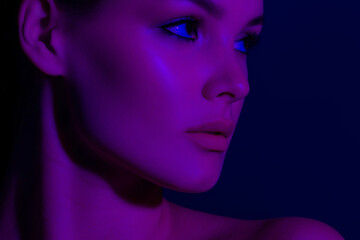 Fototapeta premium Serene portrait of young caucasian female in neon purple lighting