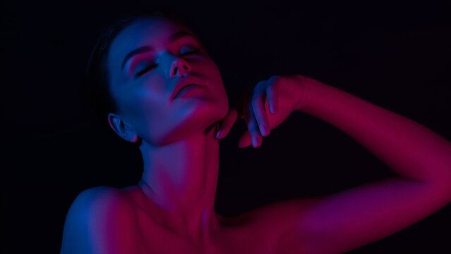 Serene female in dramatic pink and blue lighting