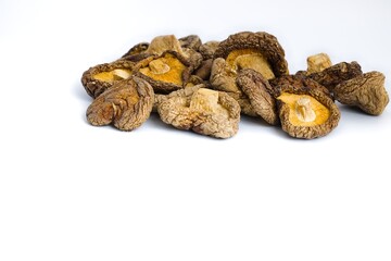 A minimalist shot of dried shiitake mushrooms on white, highlighting their textured surfaces and natural beauty.