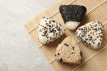 Tasty onigiri (Japanese rice balls) on grey table, top view