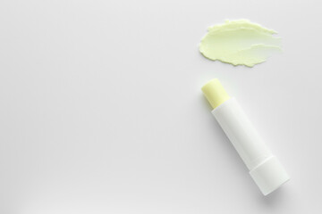 Stick of lip balm and sample on white background, top view. Space for text